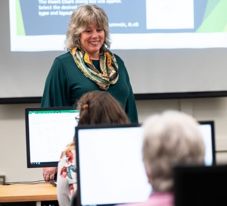 an instructor in front of trainees in a computer lab