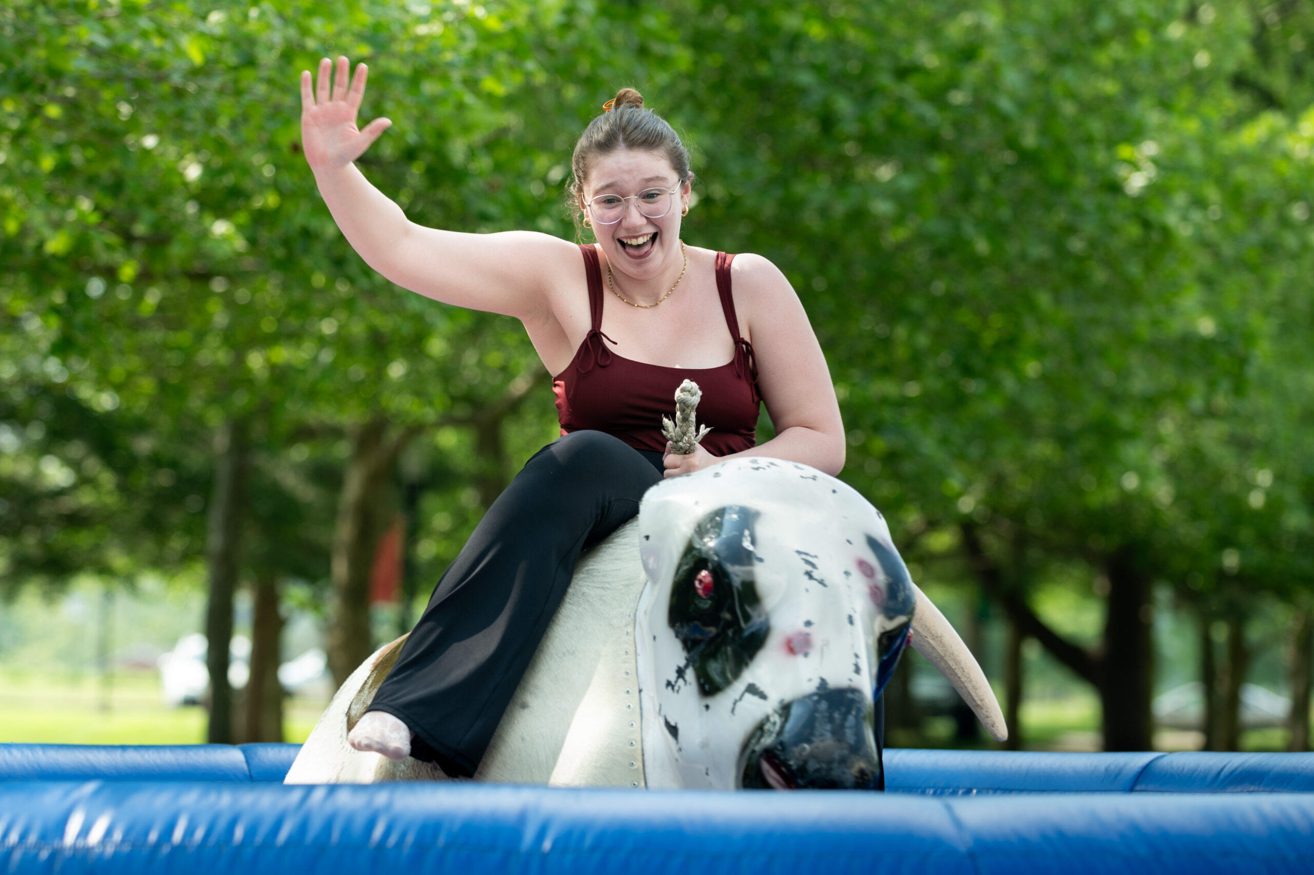 Student riding a mechanical bull like the one scheduled to be at Welcome to Fall Fest